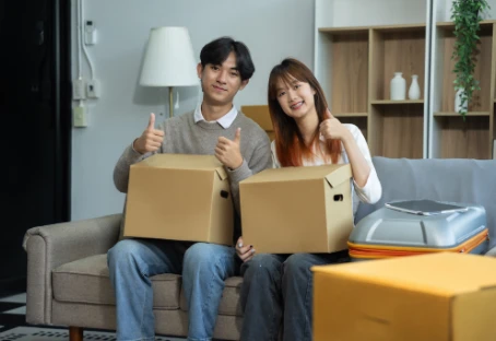 A couple unpacking moving boxes in their new rental home.